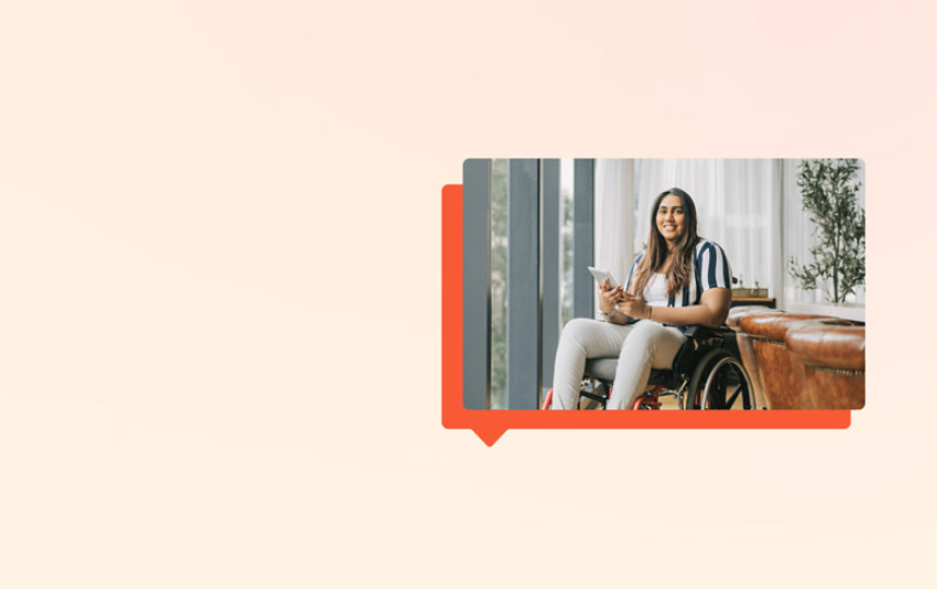 A woman sitting in a wheelchair, holding a tablet.