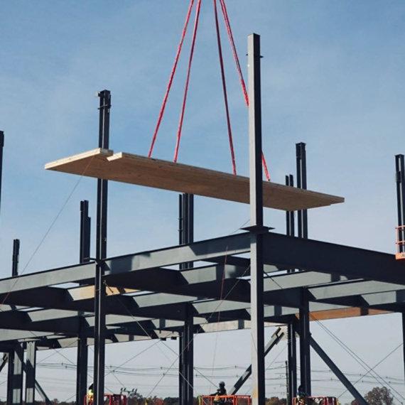 Wood panels being lifted in a construction site.