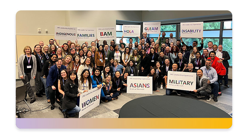 A large group of employees gather with signs representing their Employee Resource Groups.