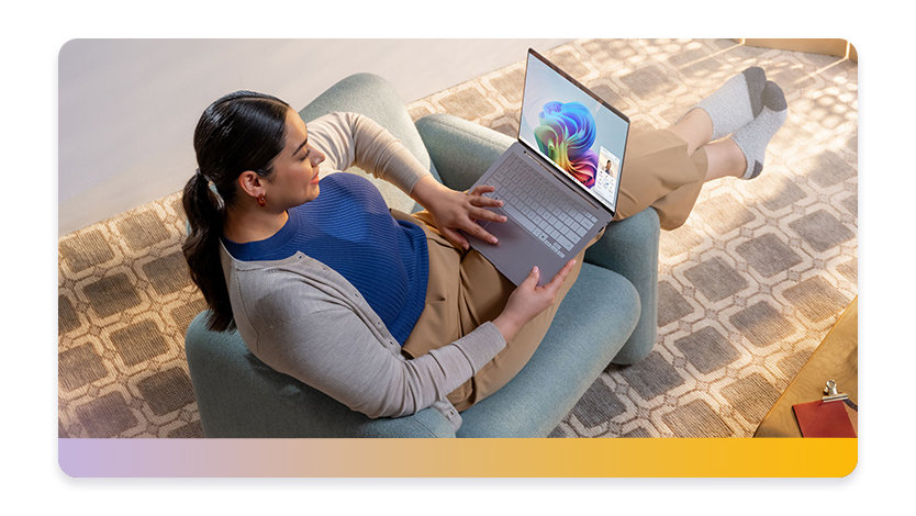 Woman lounging in a chair working on a Surface laptop