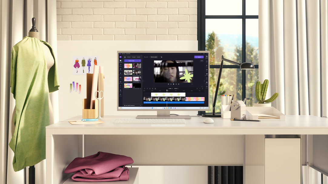 A computer monitor on a desk with writing utensils, scissors, and small color swatches
