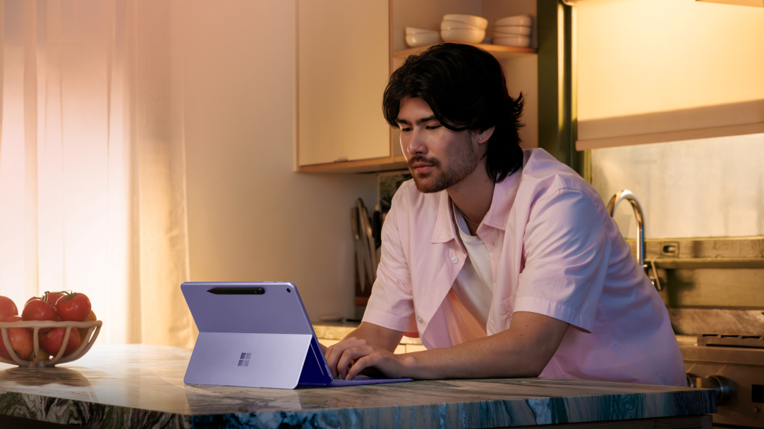 An image of a man using a Surface Pro at his kitchen counter