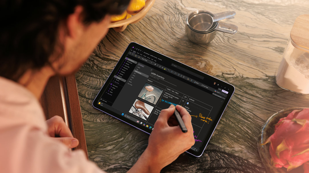 An image of a man using a Surface Slim Pen and a Surface Pro, Copilot+ PC in tablet mode