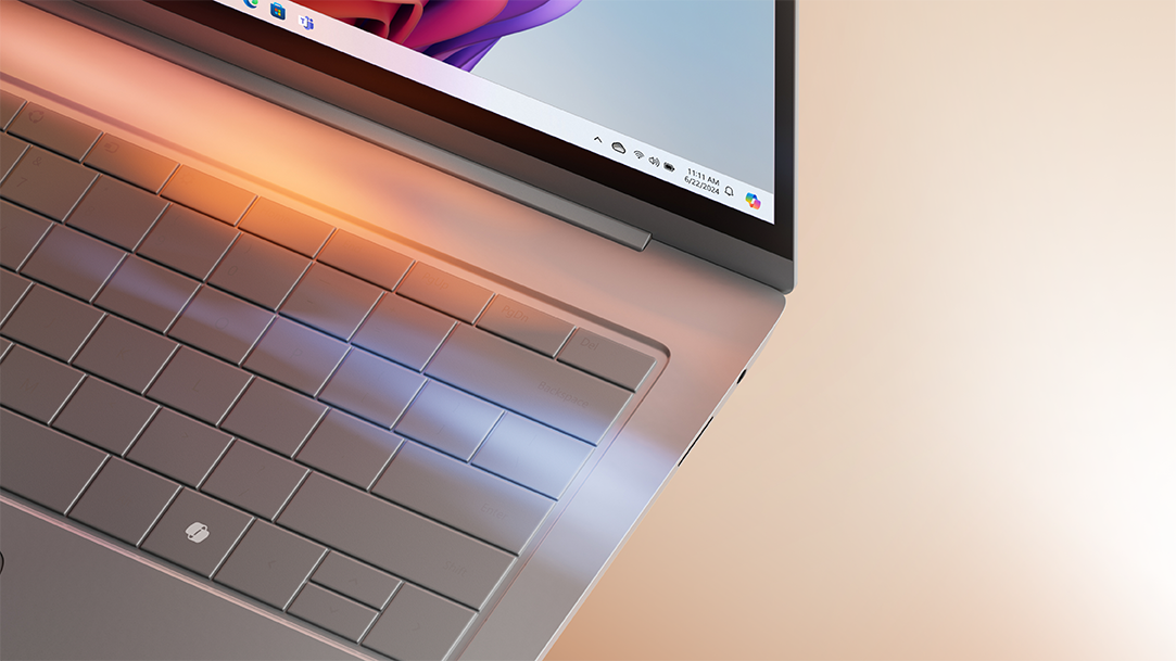 An image of laptop with the Copilot+ PC Bloom pictured on the screen and Copilot key on the keyboard