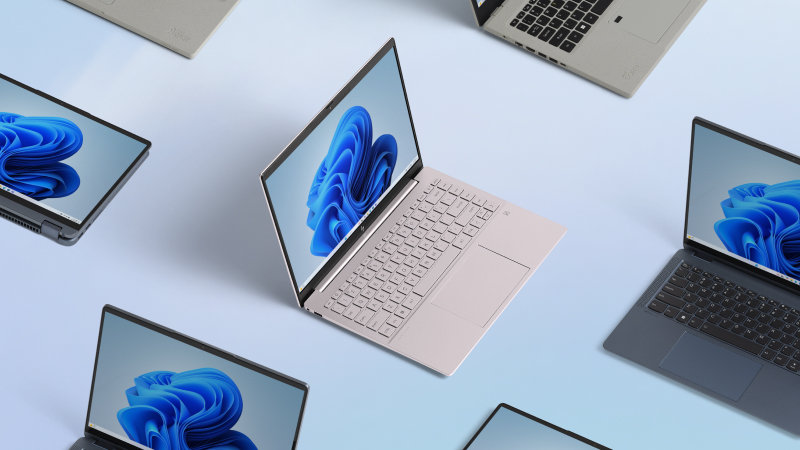 An array of open devices with the blue Microsoft bloom on each screen on a light blue background