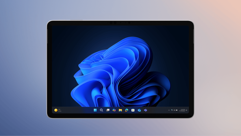 2-in-1 device displaying the Windows 11 operating system with blue bloom. The taskbar shows icons for applications like File Explorer and Microsoft Edge.