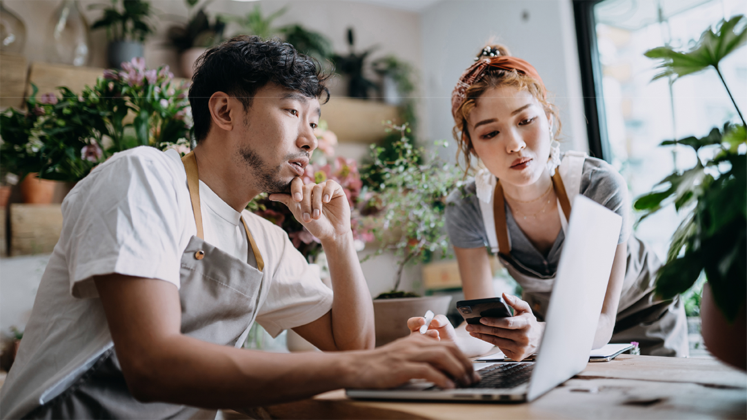 Flower shop owners look up how to sync their phone with their computer for productivity