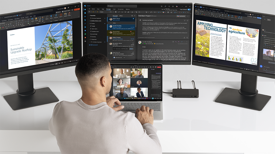 Image of a man collaborating on a Copilot+ PC Surface Laptop on a Teams call with 3 monitors