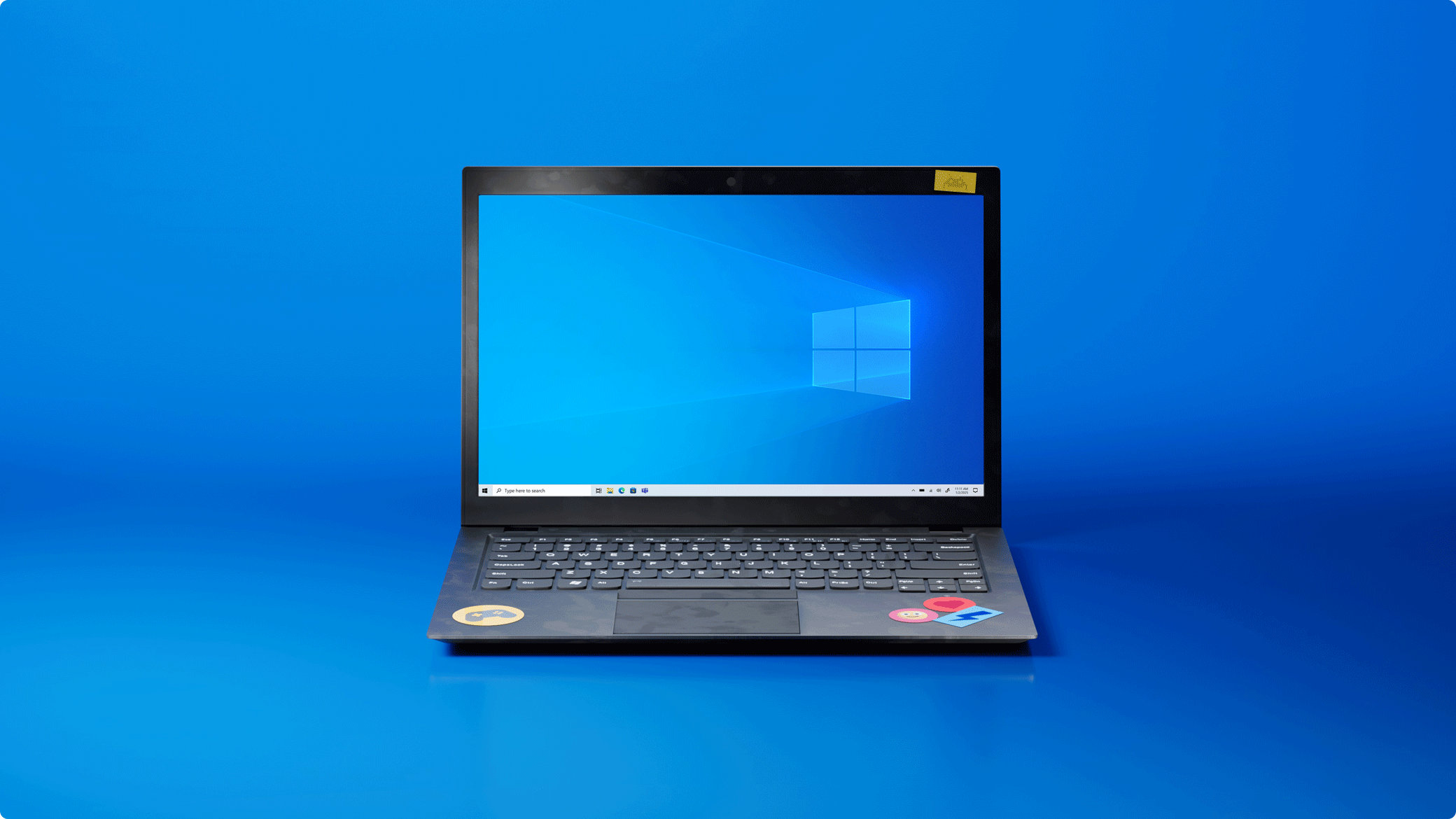 An open Windows 10 Microsoft laptop with a Windows 10 logo on the screen on a blue background