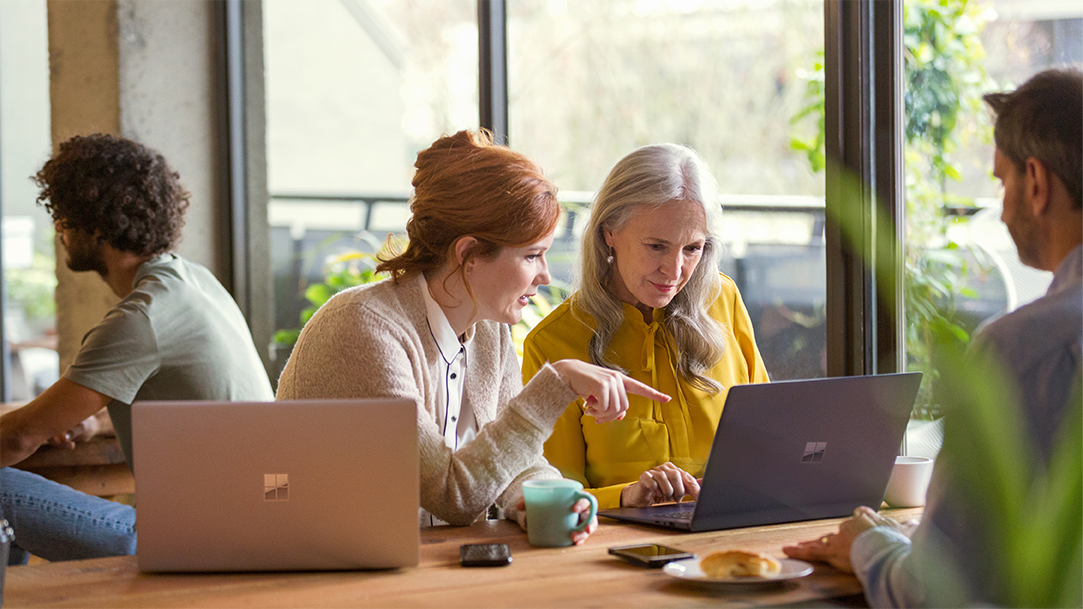 Two creative businesswomen have an informal meeting in modern open plan office