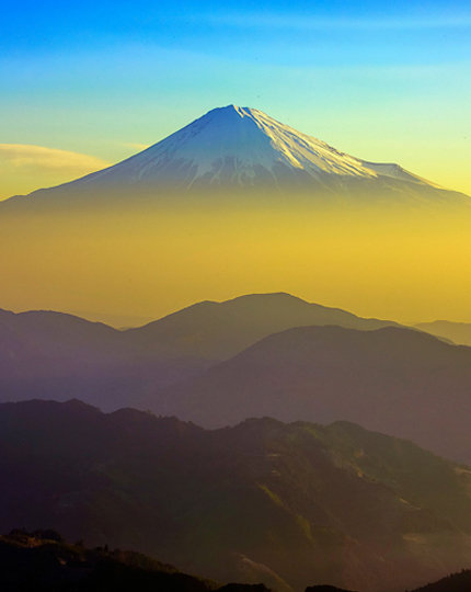 A hazy image of Mt Fuji with a blue sky