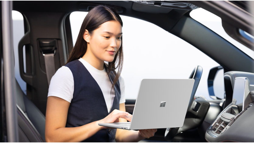 Person using Surface Laptop in car