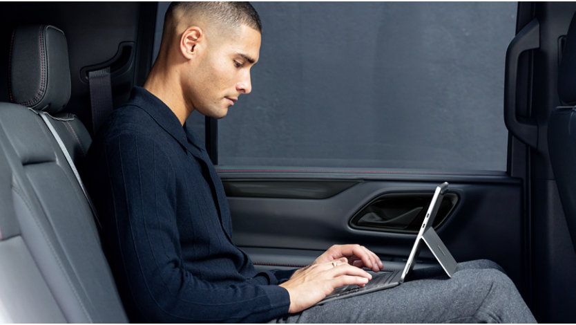 Person sitting in car working on Surface Pro
