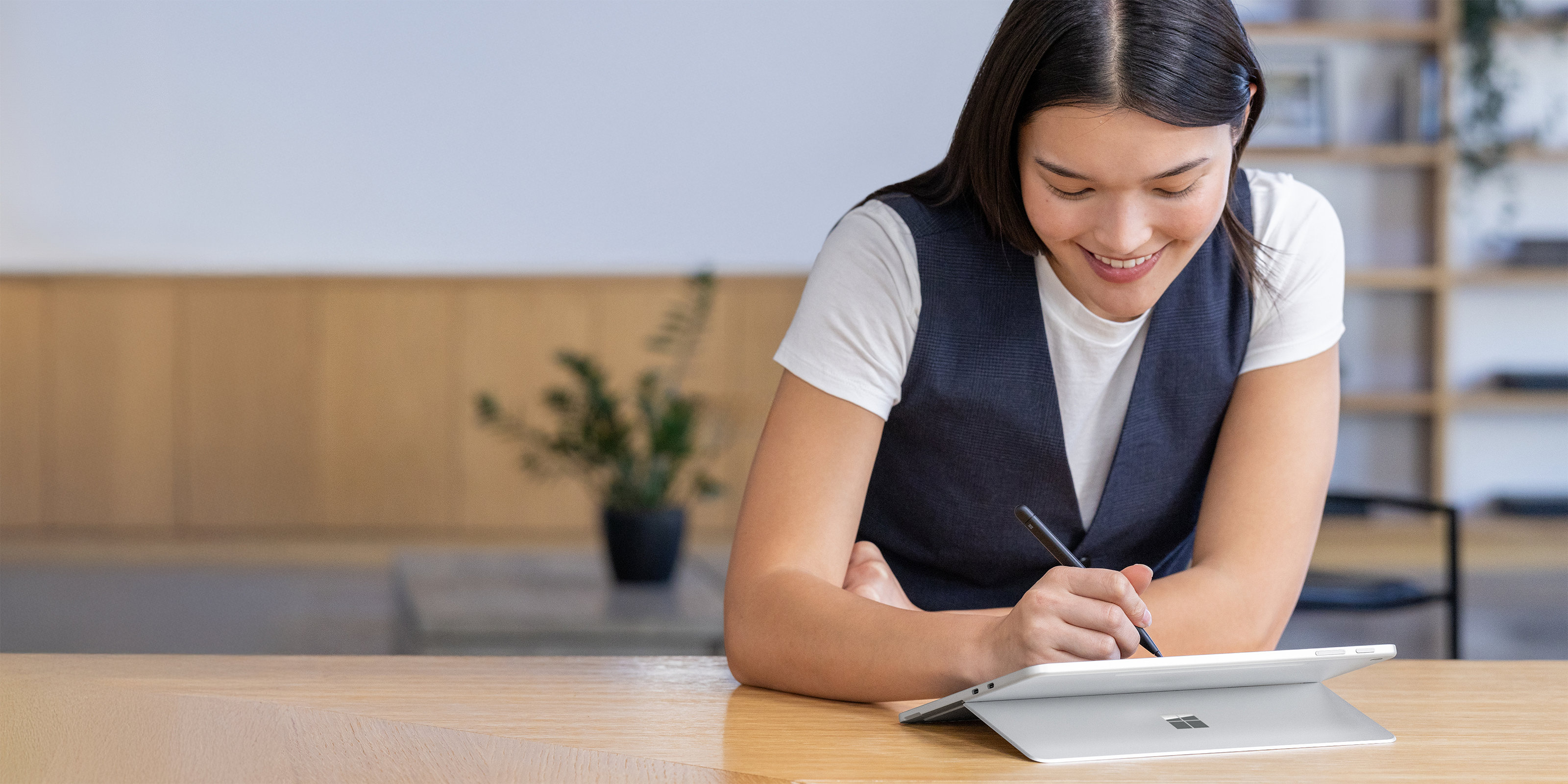 Woman sitting at her office desk using a Surface Pro