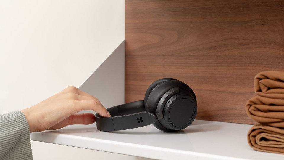 شخص يلتقط Surface Headphones 2 من رف